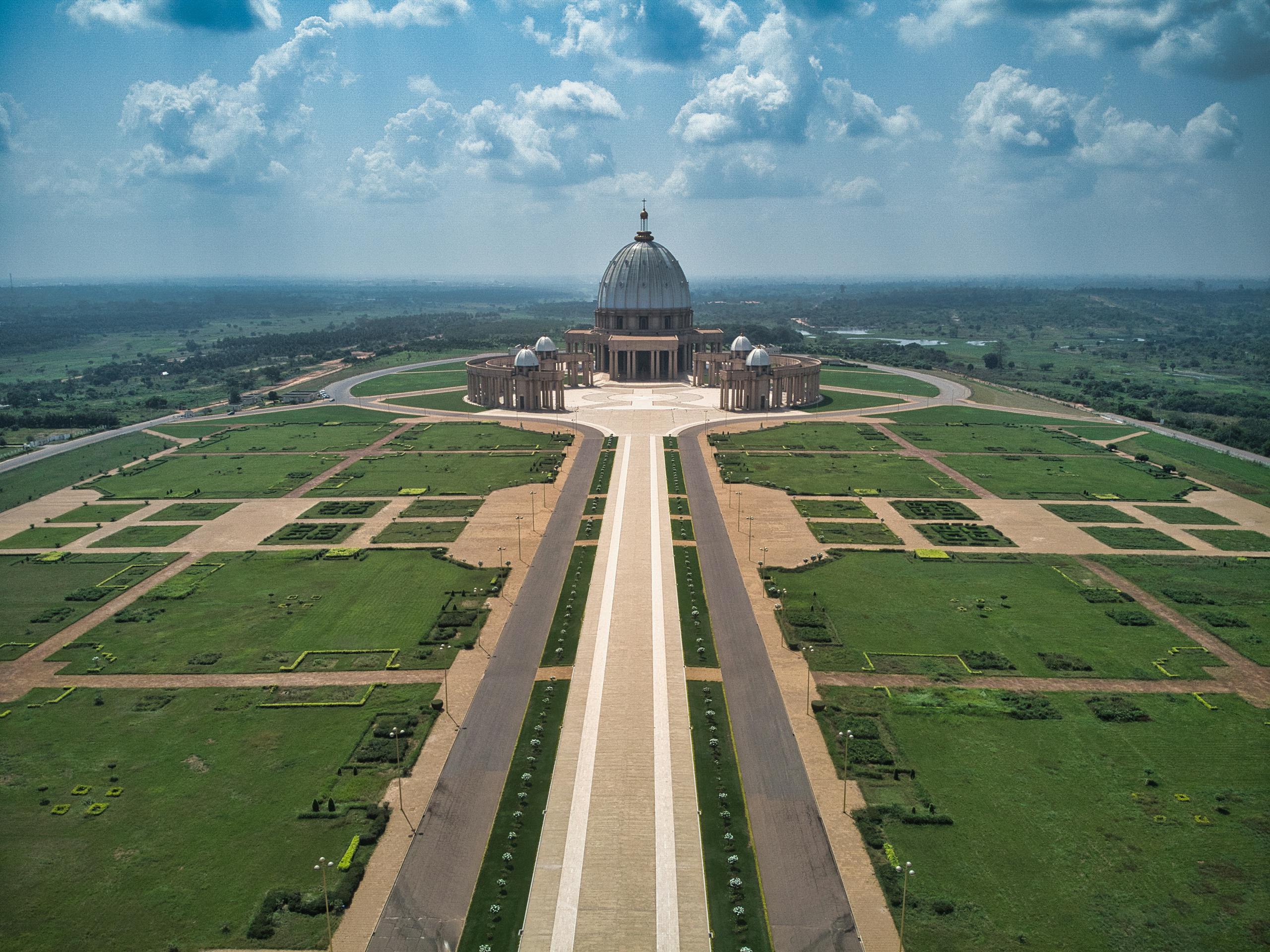 Drone shot of the Basilica of Our Lady of Peace with expansive gardens in Yamoussoukro, Côte d'Ivoire.